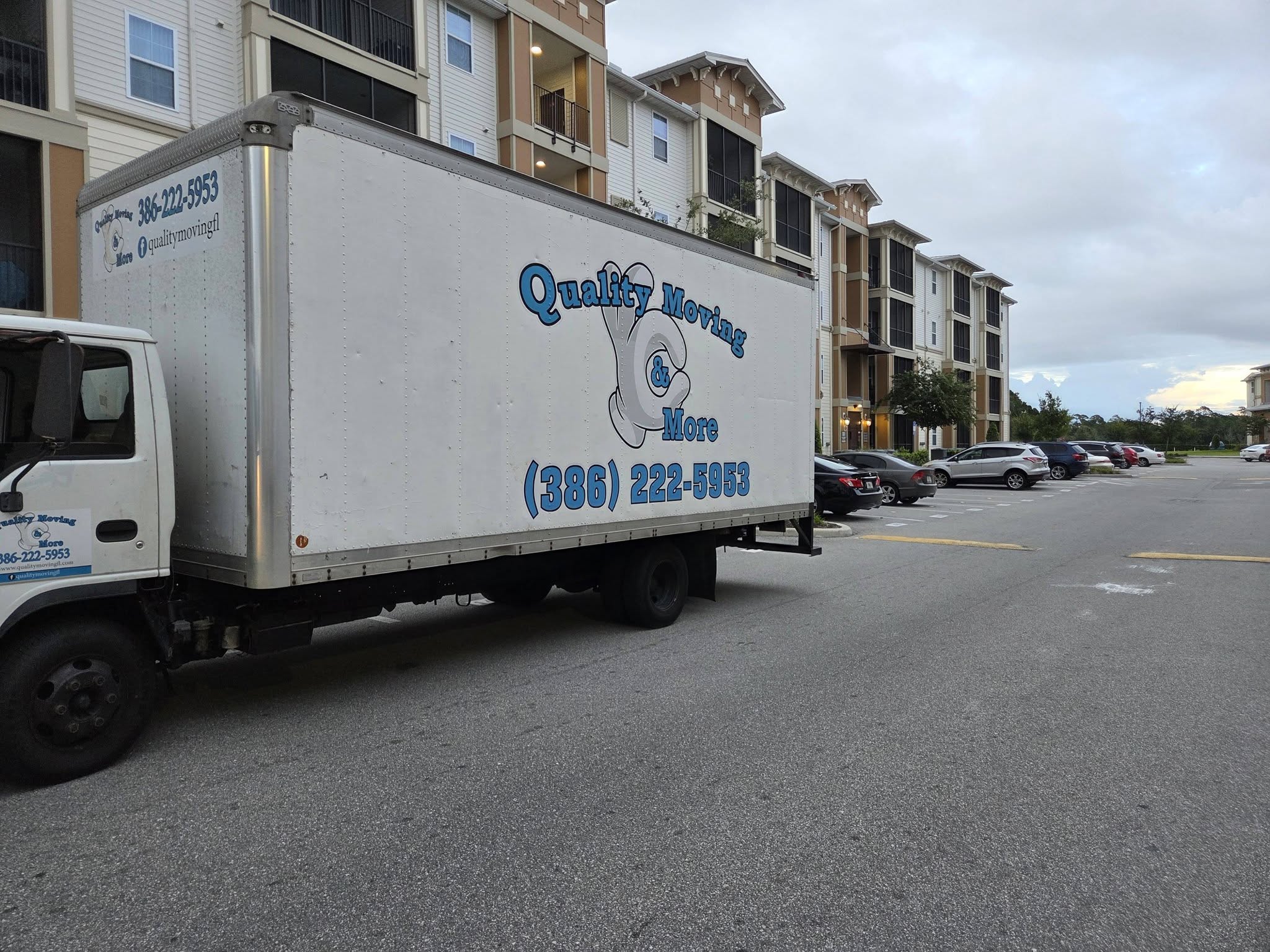 Quality Moving & More box truck parked outside an apartment building
